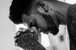 Tattooed Man Praying For Strength