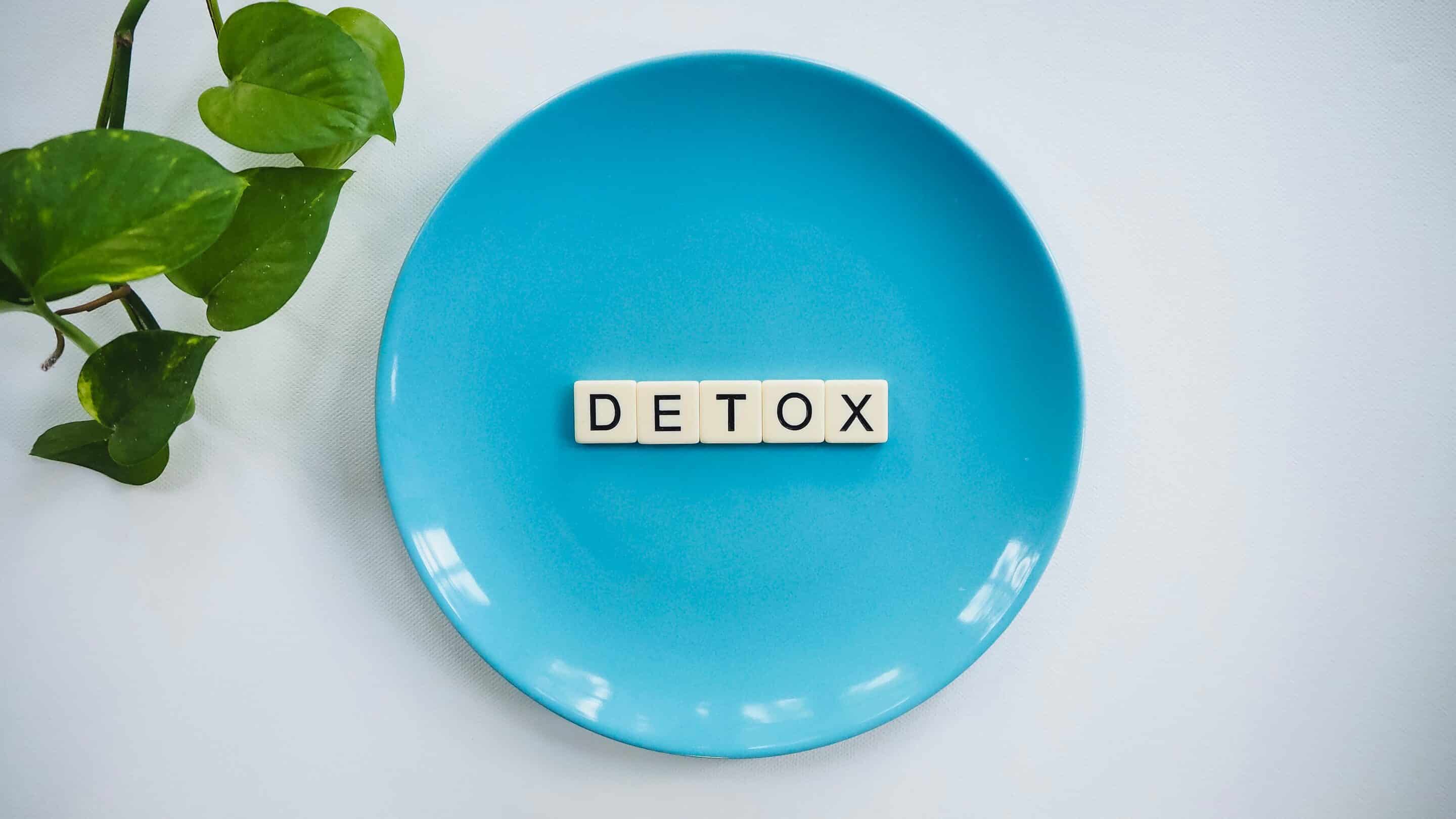 Detox spelled on a plate with game pieces