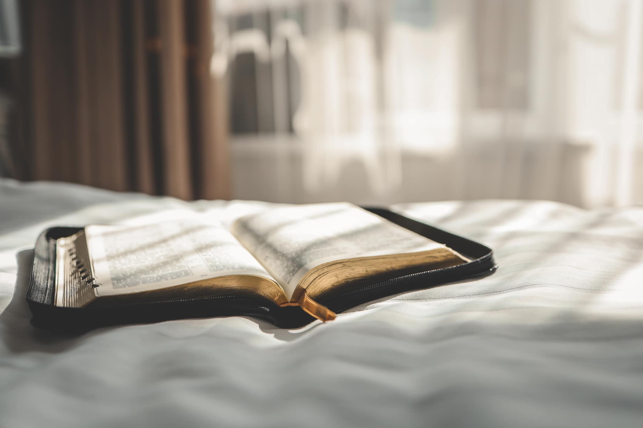 Open Bible on the bed, morning prayer.