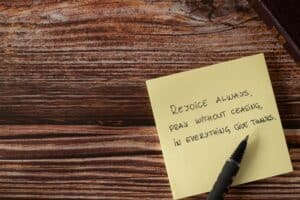 A summary of some of the best Bible verses for stress, written on a yellow sticky pad